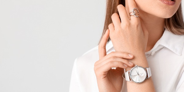 Frau mit stilvoller Armbanduhr auf weißem Hintergrund